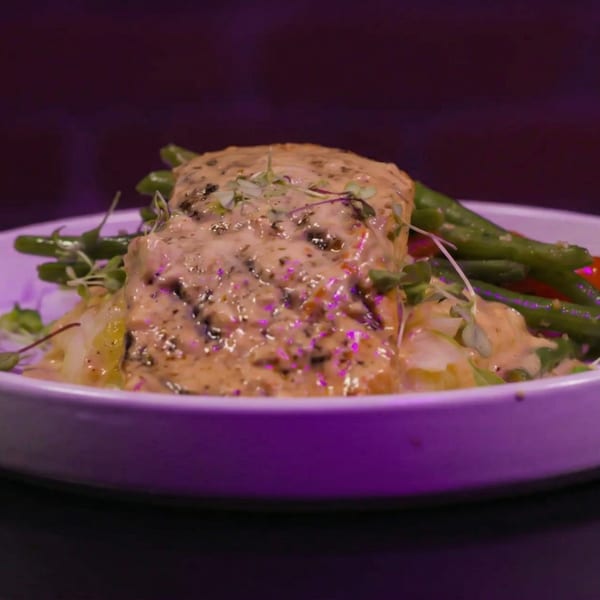 Creamy chicken dish with green beans and mashed potatoes, garnished with microgreens.